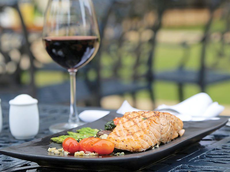 White wine or a light red pairs well with grilled salmon and other seafood dishes